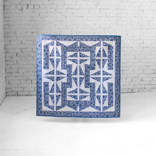 The 1751 Quilt Pattern (Download) quilt displayed in blue and white geometric shapes with a floral border, designed by Millie & Bun Designs, perfect for intermediate quilters.