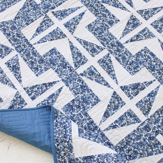 Close-up of a blue and white geometric quilt featuring floral patterns, showcasing The 1751 Quilt Pattern (Download) by Millie & Bun Designs, ideal for confident beginner quilters.