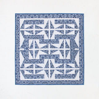 A blue and white geometric quilt featuring a complex repeating pattern designed by Millie & Bun Designs, showcasing The 1751 Quilt Pattern (Download).