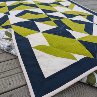 Close-up of a modern geometric quilt in navy, olive green, and cream, showcasing intricate piecing and quilting from Millie & Bun Designs' The 279 Quilt Pattern (Download).