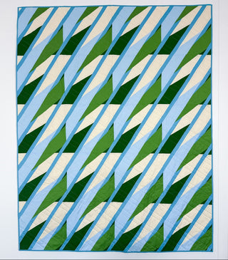 Modern quilt with geometric diagonal blocks in shades of green, blue, and cream, designed by Julia Wachs Designs for Alderbrook Quilt Pattern (Download).