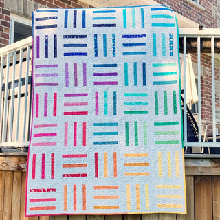 Brightly colored modern quilt with vertical and horizontal strips in a rail fence style pattern, showcasing the Bar Code Quilt Pattern (Download) by Penny Spool Quilts.