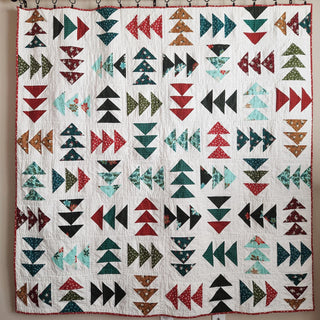 Blessings Quilt Pattern (Download) by Homemade Emily Jane, a modern geometric quilt with colorful arrow and triangle blocks on a light background.