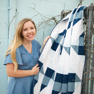 Homemade Emily Jane holds a blue and white geometric quilt featuring flowing cloud inspired shapes Cirrus Quilt Pattern (Download)