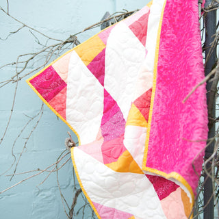 Cirrus Quilt Pattern (Download) by Homemade Emily Jane featuring a modern geometric quilt in pink white orange and yellow with flowing cloud inspired quilting