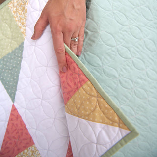 Cirrus Quilt Pattern (Download) by Homemade Emily Jane showing a modern geometric quilt with pastel green pink mustard and white fabrics and flowing quilting