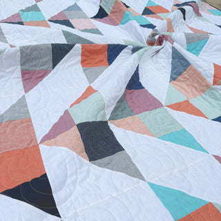 Cirrus Quilt Pattern (Download) by Homemade Emily Jane featuring a modern geometric quilt in soft blue coral gray and white with flowing shapes