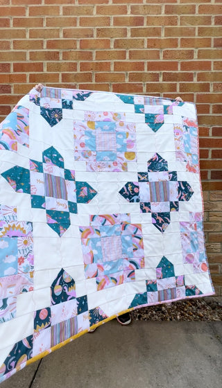 Bright quilt featuring whimsical celestial and rainbow patterns in soft pastel blues, pinks, and greens, made using City Lights Quilt Pattern (Download) by Lou Orth Designs.