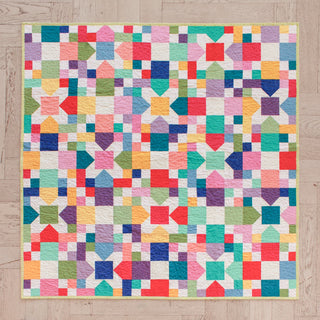 Colorful patchwork quilt displaying geometric shapes and vibrant squares in a cheerful layout, showcasing the Confetti Garden Quilt Pattern (Download) by Straight Stitching.