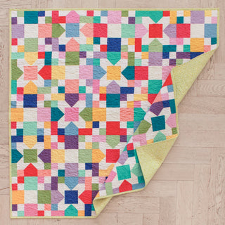 Bright and colorful Confetti Garden Quilt Pattern (Download) with geometric shapes and a soft yellow backing, perfect for beginner quilting by Straight Stitching.