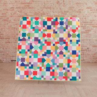 Bright and colorful quilt with geometric shapes and squares, showcasing the Confetti Garden Quilt Pattern (Download) by Straight Stitching in a cheerful, beginner-friendly style.
