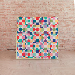 Confetti Garden Quilt Pattern (Download) by Straight Stitching features a colorful patchwork quilt with a playful geometric design perfect for beginner quilters.