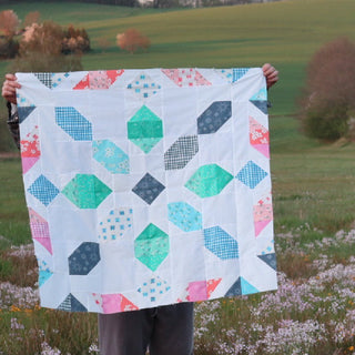 Connector Quilt Pattern (Download) by Homemade Emily Jane featuring a modern geometric quilt with colorful patchwork blocks displayed outdoors