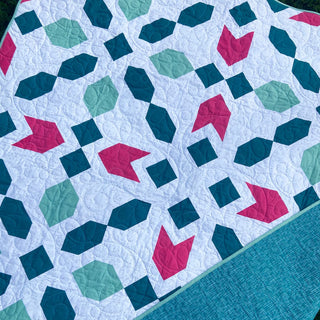 Connector Quilt Pattern (Download) by Homemade Emily Jane featuring a modern geometric quilt with teal pink and mint shapes on a white background