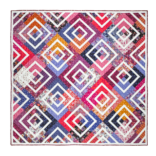 Colorful quilt with geometric diamond shapes in pink, purple, orange, and blue shades, showcasing the Coreina Quilt Pattern (Download) by A Piece of Quiet Quilts