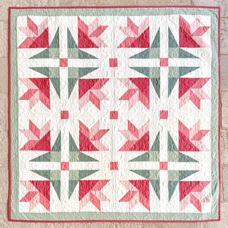 Dancing Lilies Quilt Pattern (Download) showing a floral-inspired patchwork quilt with pink and green geometric lilies, designed by Shadow Valley Quilts.