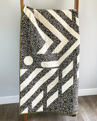 Faceoff Quilt Pattern (Download) by Jessica Steele Design featuring a black and cream geometric hockey inspired quilt with chevrons and puck motifs