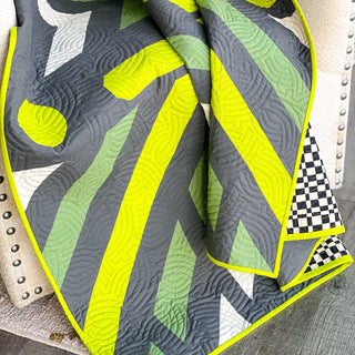 Faceoff Quilt Pattern (Download) by Jessica Steele Design featuring a bold geometric quilt in gray neon yellow green and white with checkerboard accents