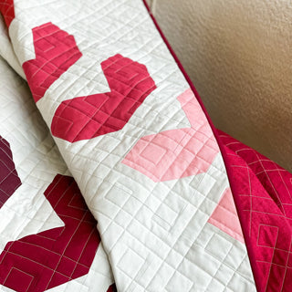Fastball 2.0 Quilt Pattern (Download) by Jessica Steele Design featuring a modern red and pink geometric quilt with white background and detailed quilting lines
