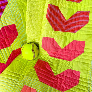 Fastball 2.0 Quilt Pattern (Download) by Jessica Steele Design featuring a lime green quilt with red baseball inspired geometric blocks and a softball accent