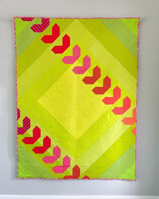 Fastball 2.0 Quilt Pattern (Download) by Jessica Steele Design featuring a bright lime green quilt with pink and red geometric baseball inspired motifs