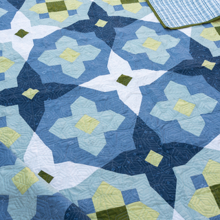 Garden Glow quilt by Toad & Sew with blue and green floral pattern on a flat surface