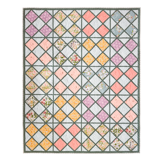 A colorful quilt featuring diamond-shaped floral and solid fabric blocks in soft pastels and muted tones, created using the Harlequin Bloom Quilt Pattern (Download) by A Piece of Quiet Quilts.