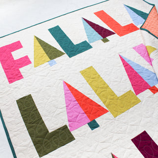 Fa-La-La Quilt Pattern (Download) by Patternly Collective featuring a colorful modern holiday quilt with playful geometric letters and festive patchwork blocks