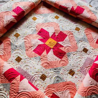 Close-up of a vibrant mauve and pink floral quilt design with circular stitching patterns, featuring the Ixora Quilt Pattern (Download) by Thai Charm.