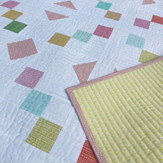 Keystone Quilt Pattern (Download) by Homemade Emily Jane showing a modern geometric quilt with colorful squares and triangles on a soft white background