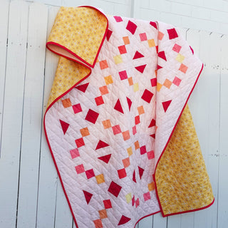 Keystone Quilt Pattern (Download) by Homemade Emily Jane showing a modern geometric quilt with pink red orange and yellow blocks and red binding