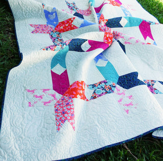 Limelight Quilt Pattern (Download) by Homemade Emily Jane featuring a modern geometric quilt with colorful teal pink and blue fabric on white negative spaceાન્ય