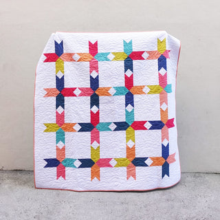 Limelight Quilt Pattern (Download) by Homemade Emily Jane showing a modern geometric quilt with colorful arrows and clean white negative space