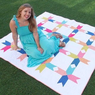 Limelight Quilt Pattern (Download) by Homemade Emily Jane featuring a colorful geometric quilt with bold shapes and clean white negative space outdoors