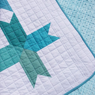 Limelight Quilt Pattern (Download) by Homemade Emily Jane featuring bold teal geometric shapes on a softly quilted white background with aqua binding
