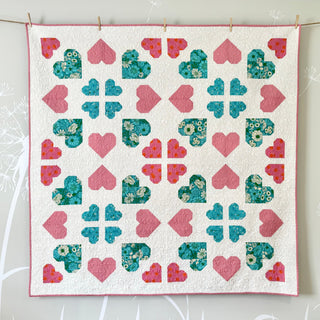 Bright quilt with pink and teal floral heart and clover shapes on white background, made using Lovelace Quilt Pattern (Download) from The Dandy Patch.