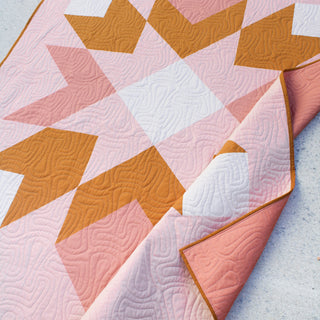 Mt. Mitchell Quilt Pattern (Download) by Hampton Quilt Studio features a modern geometric quilt in pink orange and white with large half square triangles and squares