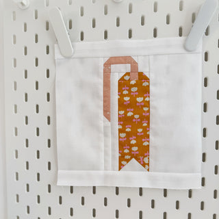 One More Page Block Pattern (Download) by Lou Orth Designs featuring a modern quilt block in soft peach and mustard floral fabric, perfect for digital quilt pattern projects.