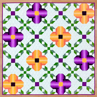 Bright floral quilt with purple and orange pansy blocks connected by green and white geometric sashing, created using the Pansy Picnic Quilt Pattern (Download) by Shadow Valley Quilts.