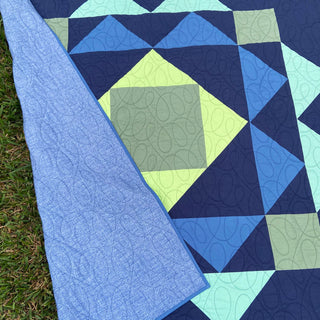 Paradigm Quilt Pattern (Download) by Homemade Emily Jane featuring a bold geometric quilt in navy blue lime green aqua and gray with looping quilting