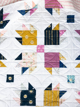 Paw Tracks quilt by Lou Orth Designs featuring triangles and squares in various colors.