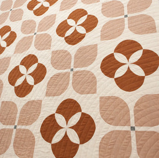 Patterned quilt with brown and beige colors in a floral motif