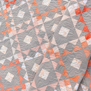 Reverberate Quilt Pattern (Download) by Homemade Emily Jane featuring a modern geometric quilt with coral pink and gray triangles and swirling quilting details