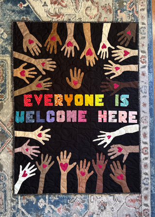 Colorful quilt featuring diverse hands with hearts and the phrase Say Something Bold Alphabet FPP Pattern (Download) by Sweet Potato Quilts on a black background.