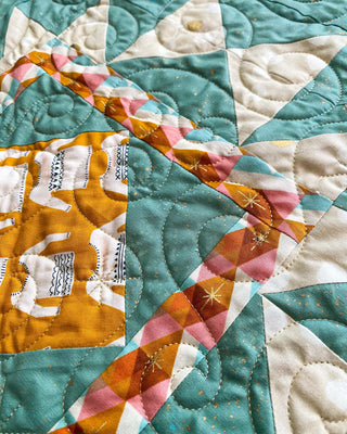 Close-up of a teal, mustard, and pink quilt block showing intricate stitching and vibrant fabrics from A Piece of Quiet Quilts featuring the Splendid Shimmer Quilt Pattern (Download).