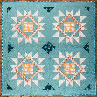 Teal and orange geometric quilt featuring hand-stitched quilting and star patterns, showcasing the Splendid Shimmer Quilt Pattern (Download) by A Piece of Quiet Quilts.