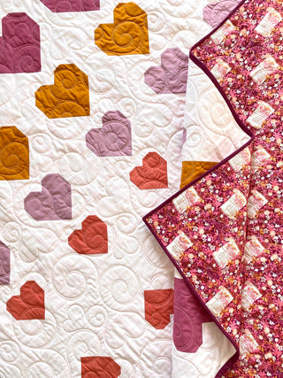 Quilt with heart patterns in various colors on a white background