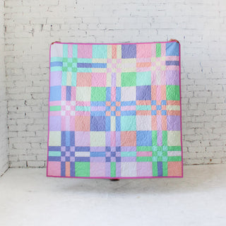 Pastel-colored quilt featuring a plaid design with intricate quilting, showcasing the To The Nines Quilt Pattern (Download) by Patternly Collective.