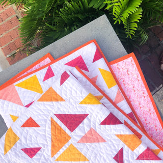 Triangular Quilt Pattern (Download) by Homemade Emily Jane featuring a modern geometric quilt with colorful triangle shapes in coral yellow pink and white
