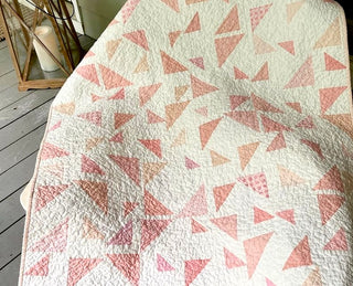 Triangular Quilt Pattern (Download) by Homemade Emily Jane featuring a modern geometric quilt with scattered pink and peach triangles on a soft white background